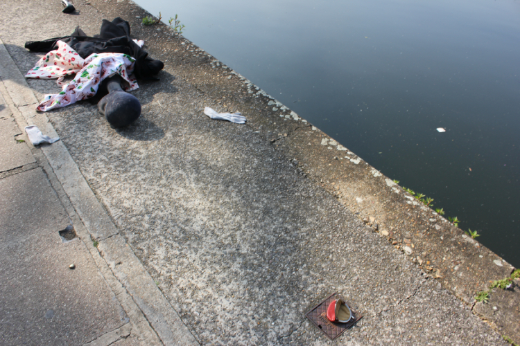 a tailor's dummy lies by the canal side